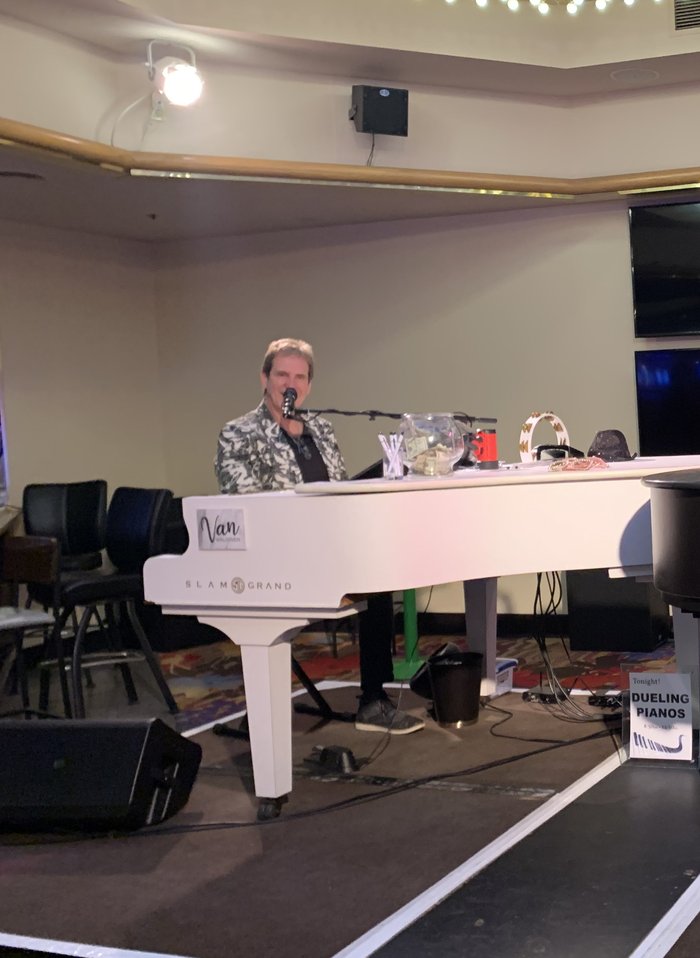 Dave Coldren performing at a white Slam Grand piano
